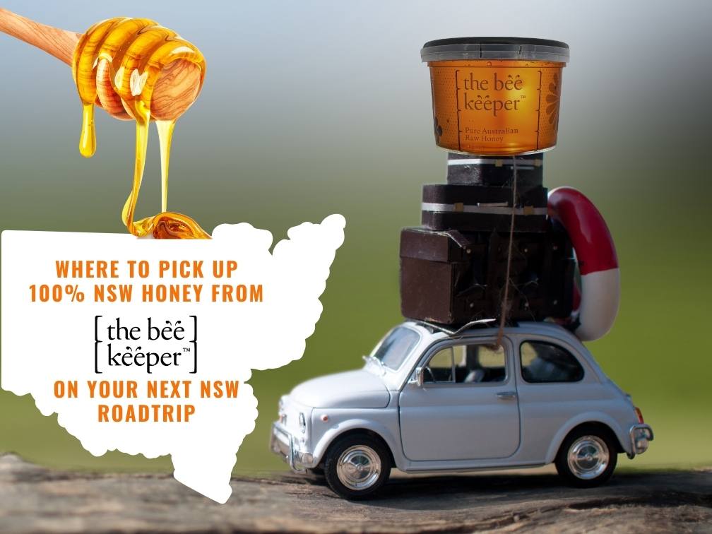 A model VW beetle with luggage strapped to the roof with a tub of honey on top.